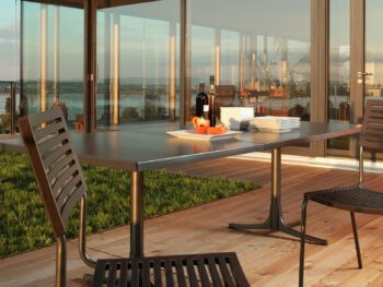 Moderner Schaffner Arbon Esstisch auf Holzdeck mit Seeblick.