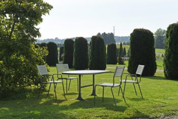 Moderner Schaffner Metall-Gartentisch Schaffhausen mit Lamello Stühlen im gepflegten Garten.