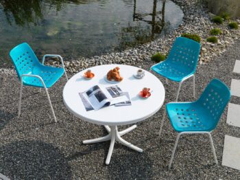 Schaffner Tisch Schaffhausen und Türkise Bermuda Stühle auf einer Terrasse.