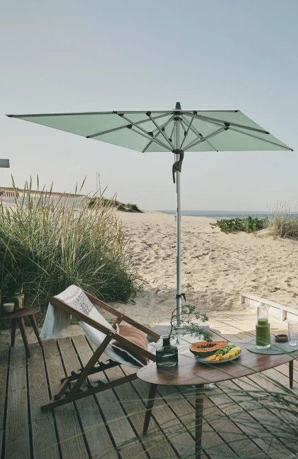 Ruhiger Strand mit windfestem Sonnenschirm.